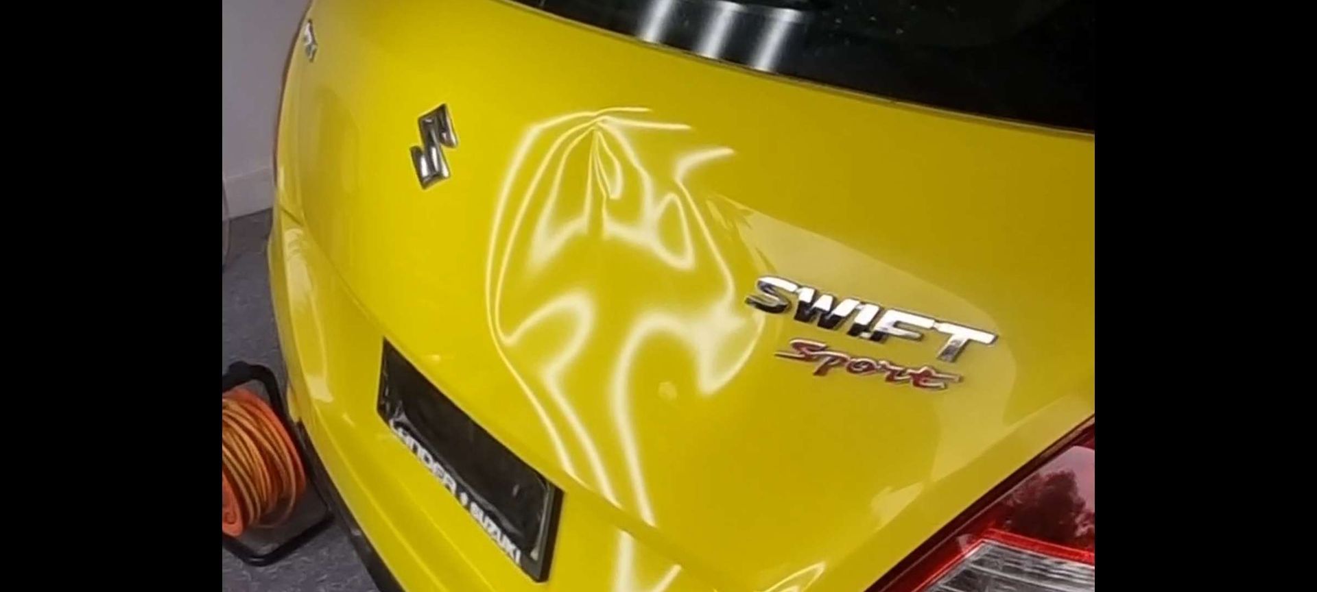 the back of a yellow swift sport car being damaged