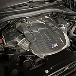 A close up of the engine of a car with the hood open.