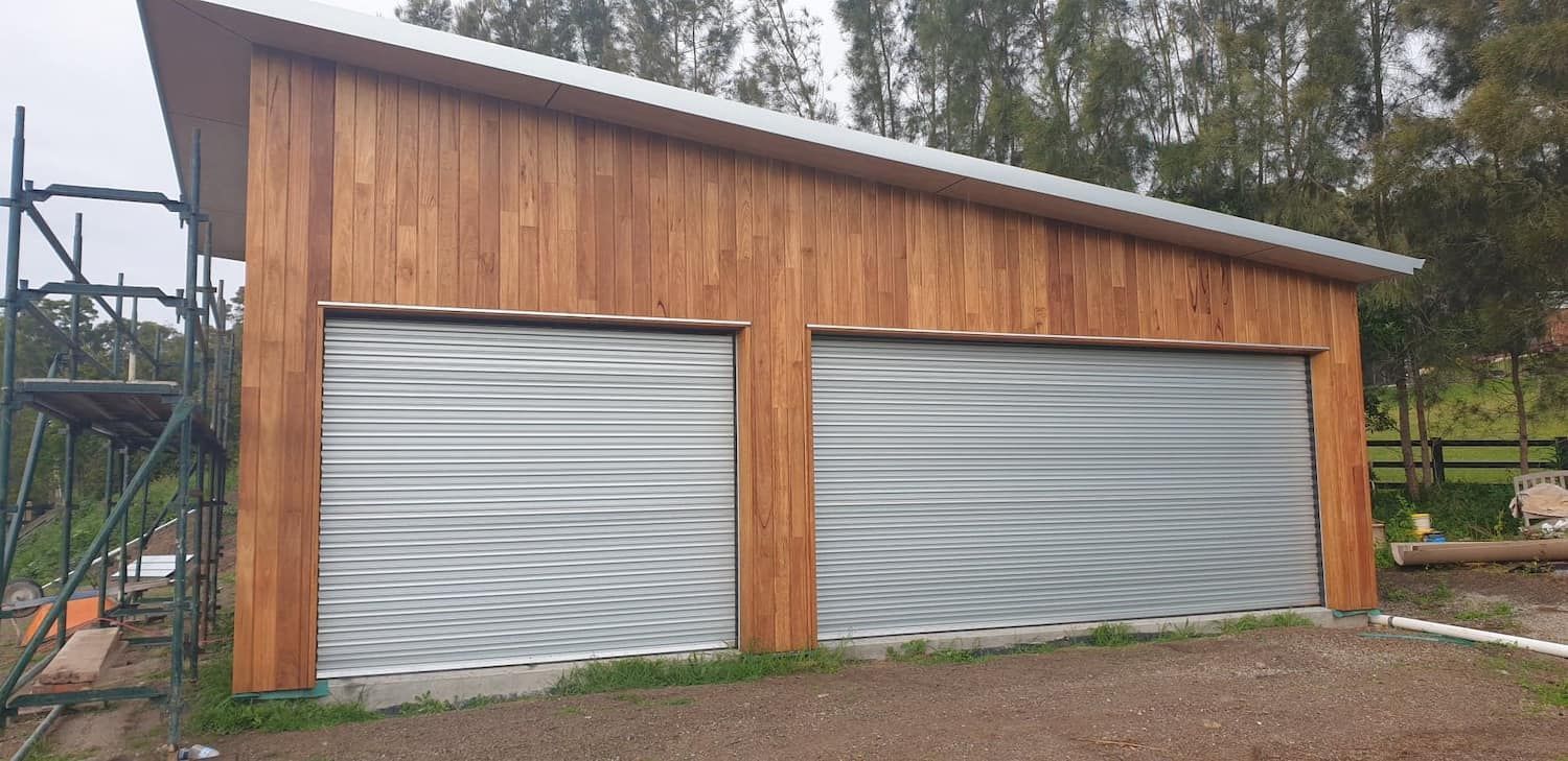 A Wooden Garage with Two Metal Garage Doors Is Being Built — Illawarra Garage Doors in Albion Park Rail, NSW