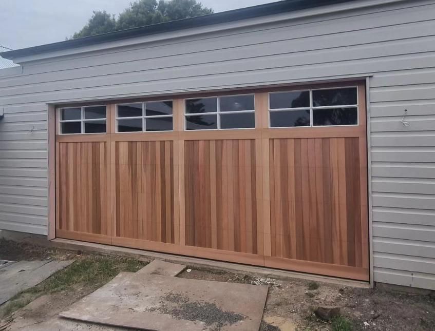 A Large Wooden Garage Door with A Lot of Windows — Illawarra Garage Doors in Bowral, NSW