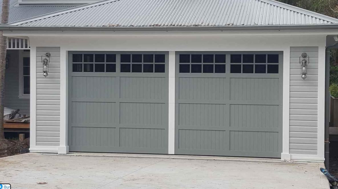 A White House with A Garage Door and A Car Parked in Front of It — Illawarra Garage Doors in Albion Park Rail, NSW