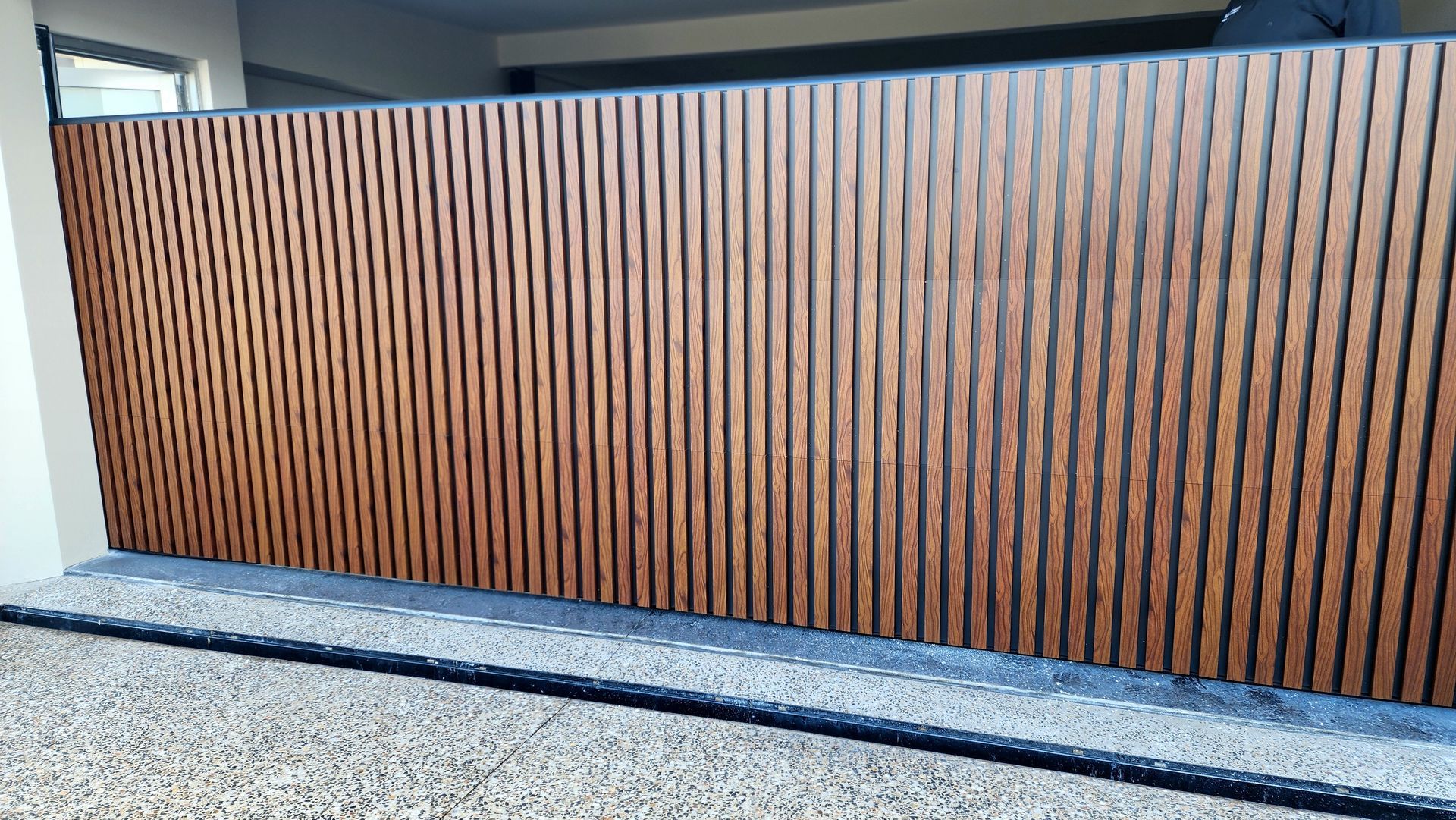 A Wooden Garage Door Is Being Built on The Side of A House — Illawarra Garage Doors in Albion Park Rail, NSW