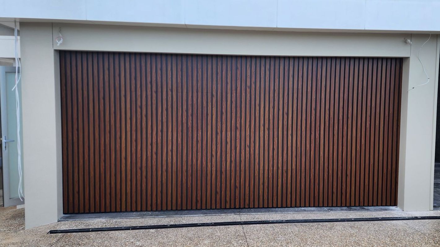 A Car Is Parked in A Garage Under a Garage Door Opener — Illawarra Garage Doors in Albion Park Rail, NSW