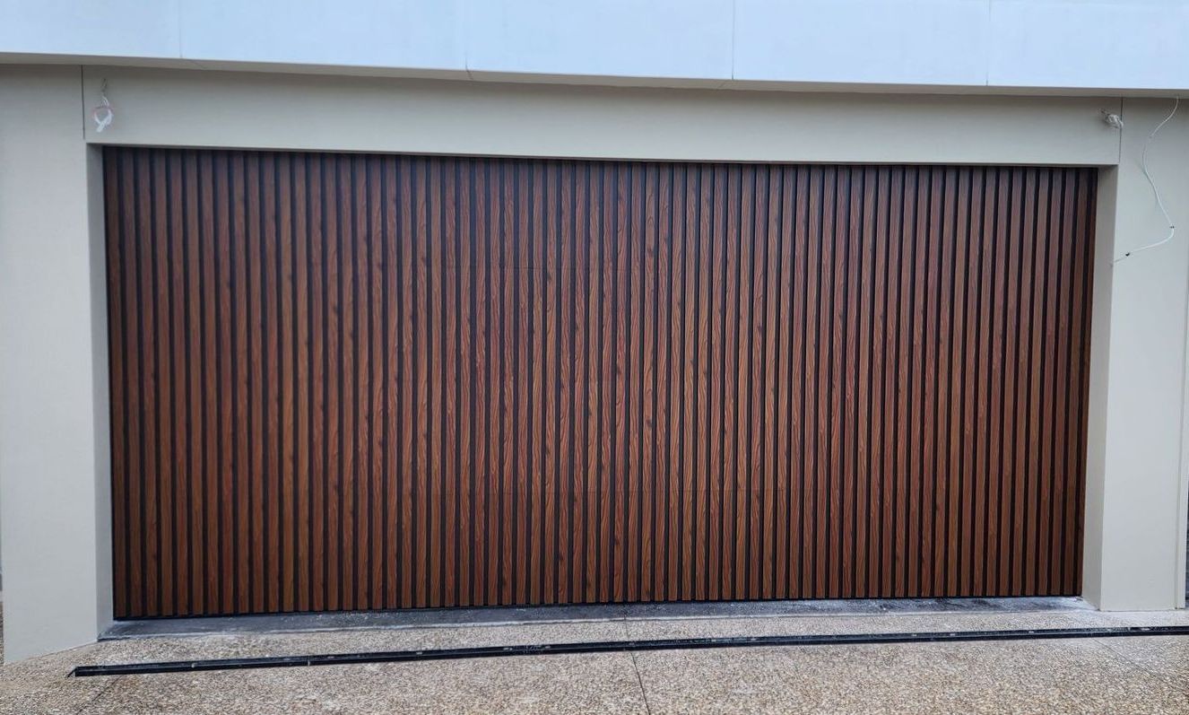 A Black and White House with A Blue Sky in The Background — Illawarra Garage Doors in Albion Park Rail, NSW