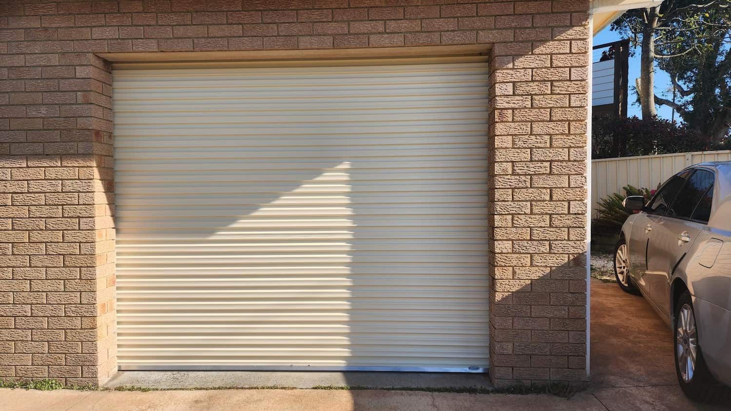 A Car Is Parked in Front of A Garage Door — Illawarra Garage Doors in Albion Park Rail, NSW