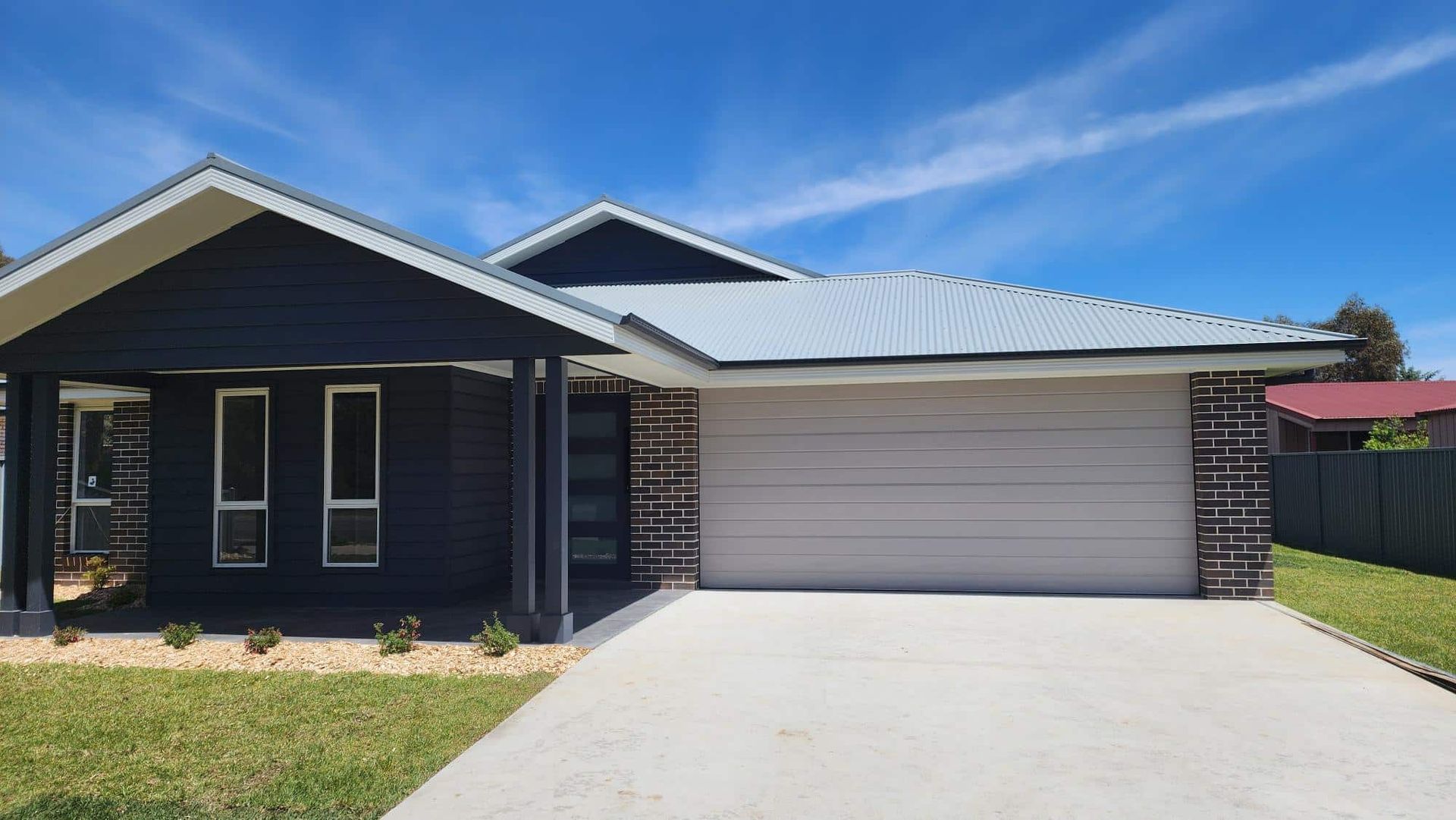A Black and White House with A White Garage Door — Illawarra Garage Doors in Albion Park Rail, NSW
