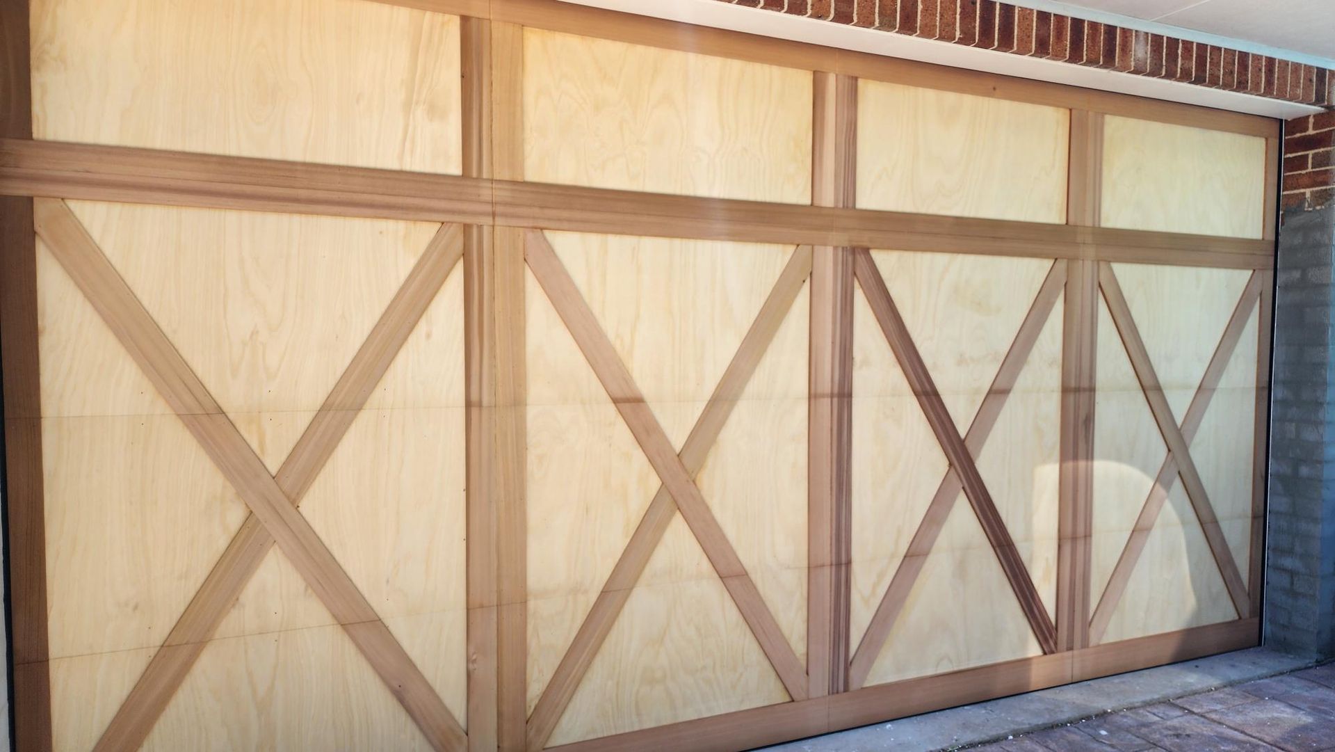 A Large Wooden Garage Door with X 's on It — Illawarra Garage Doors in Albion Park Rail, NSW