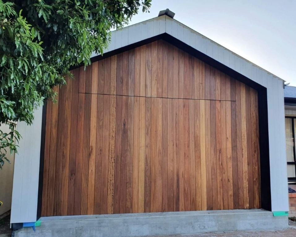 A House with A Wooden Garage Door and A Tree in Front of It — Illawarra Garage Doors in Thirroul, NSW