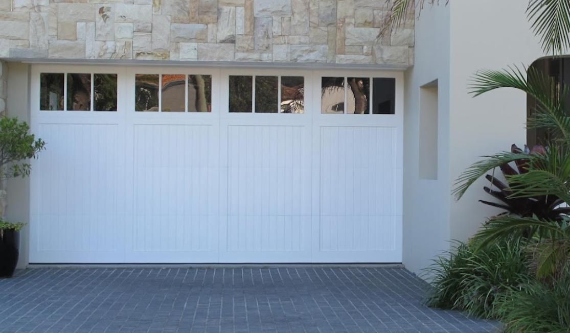 A Row of Blue Garage Doors with Yellow Pillars — Illawarra Garage Doors in Wollongong, NSW