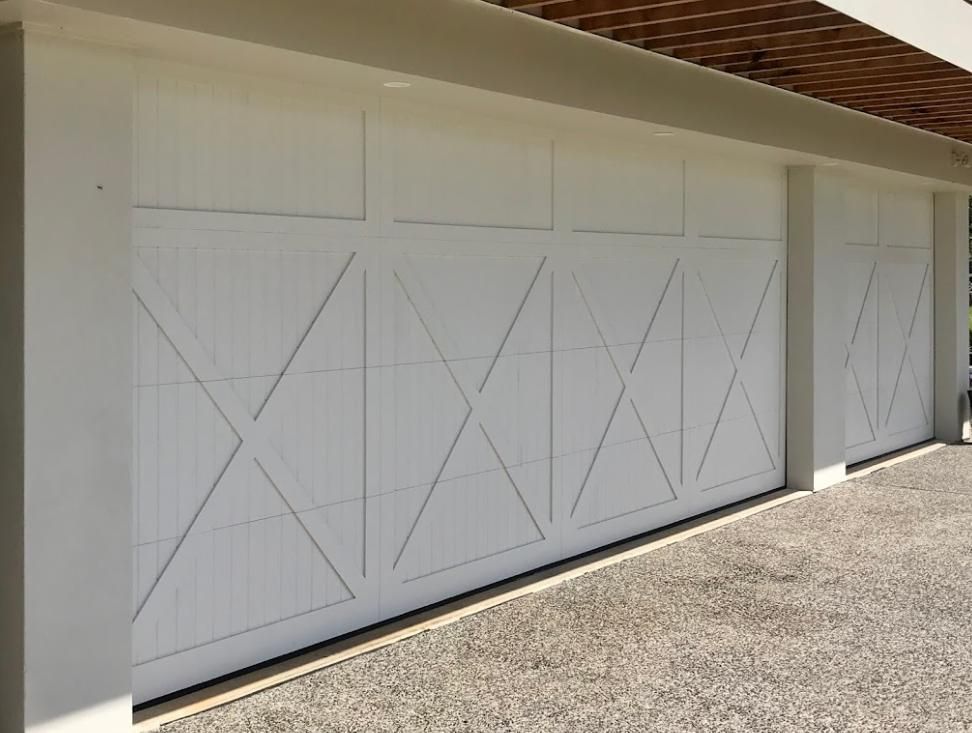 Two White Garage Doors Are Sitting Next to Each Other — Illawarra Garage Doors in Albion Park, NSW