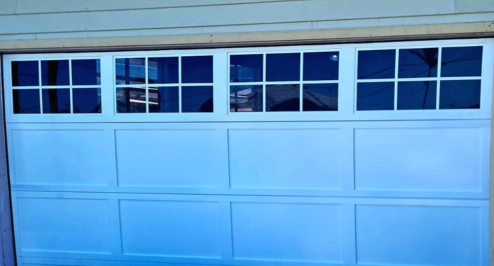 A Blue Garage Door with A Lot of Windows on It — Illawarra Garage Doors in Albion Park Rail, NSW