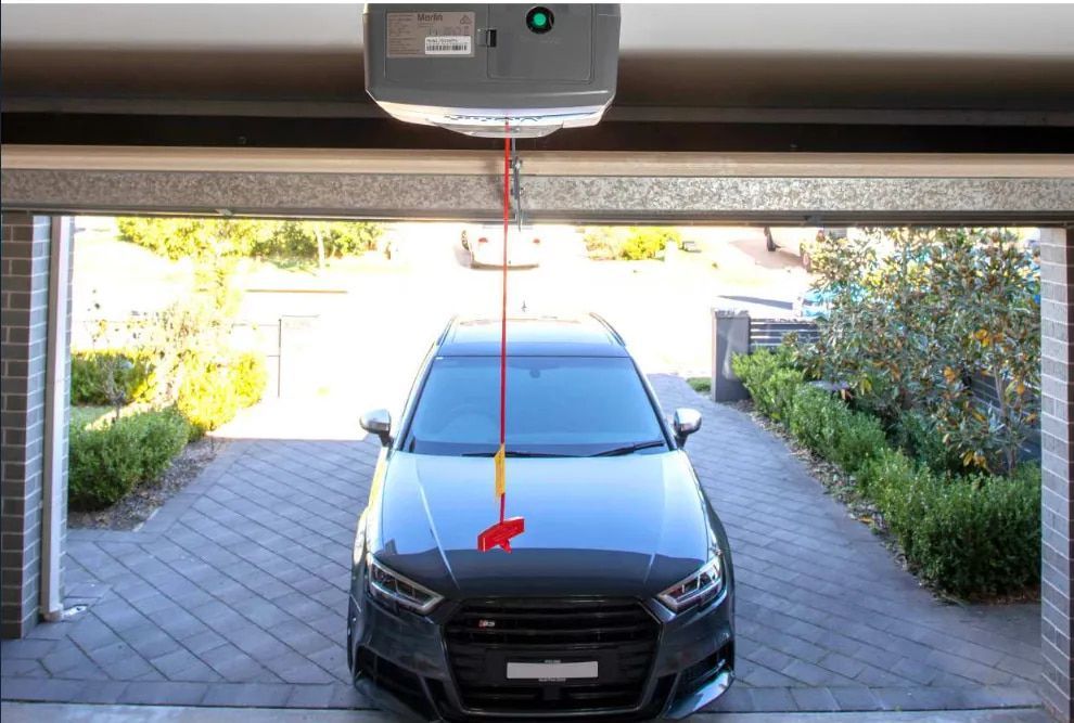 A Car Is Parked in A Garage Under a Garage Door Opener — Illawarra Garage Doors in Wollongong, NSW