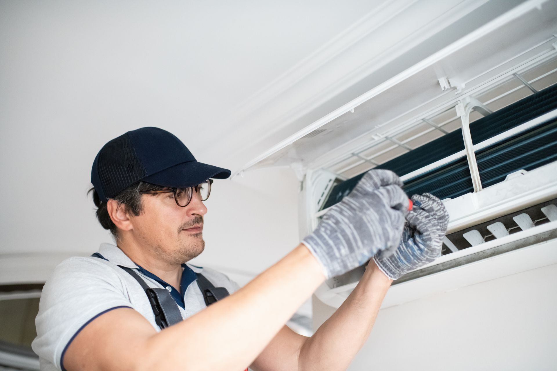 A man is working on an air conditioner in a room. A man is working on an air conditioner in a room.