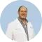 Doctor in a white coat standing against a light blue circular background