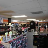 Cluttered retail store interior with racks of clothes, shelves, and hanging merchandise