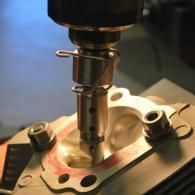 CNC milling machine cutting a metal engine part with a rotating drill bit