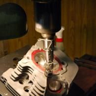 Close-up of a CNC machine milling a metal engine cylinder head.