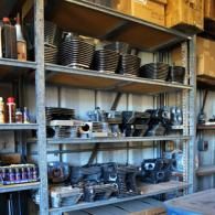 Metal shelving stocked with stacked black dishes and cookware in a storage room