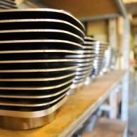 Stacks of black-and-white striped bowls on wooden shelves in a kitchen storage area