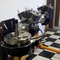 Two motorcycle engines on display in a room with a black-and-white checkered floor.