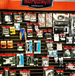 Motorcycle accessory display with Kuryakyn products on red wall racks