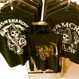 Black graphic T-shirts on a rack, including one with a skull and “Sons of Anarchy” logo