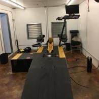 Indoor training room with a treadmill, exercise equipment, and a wall-mounted screen