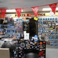Parts and service counter with wall displays of small items and red pennant banners in an auto shop