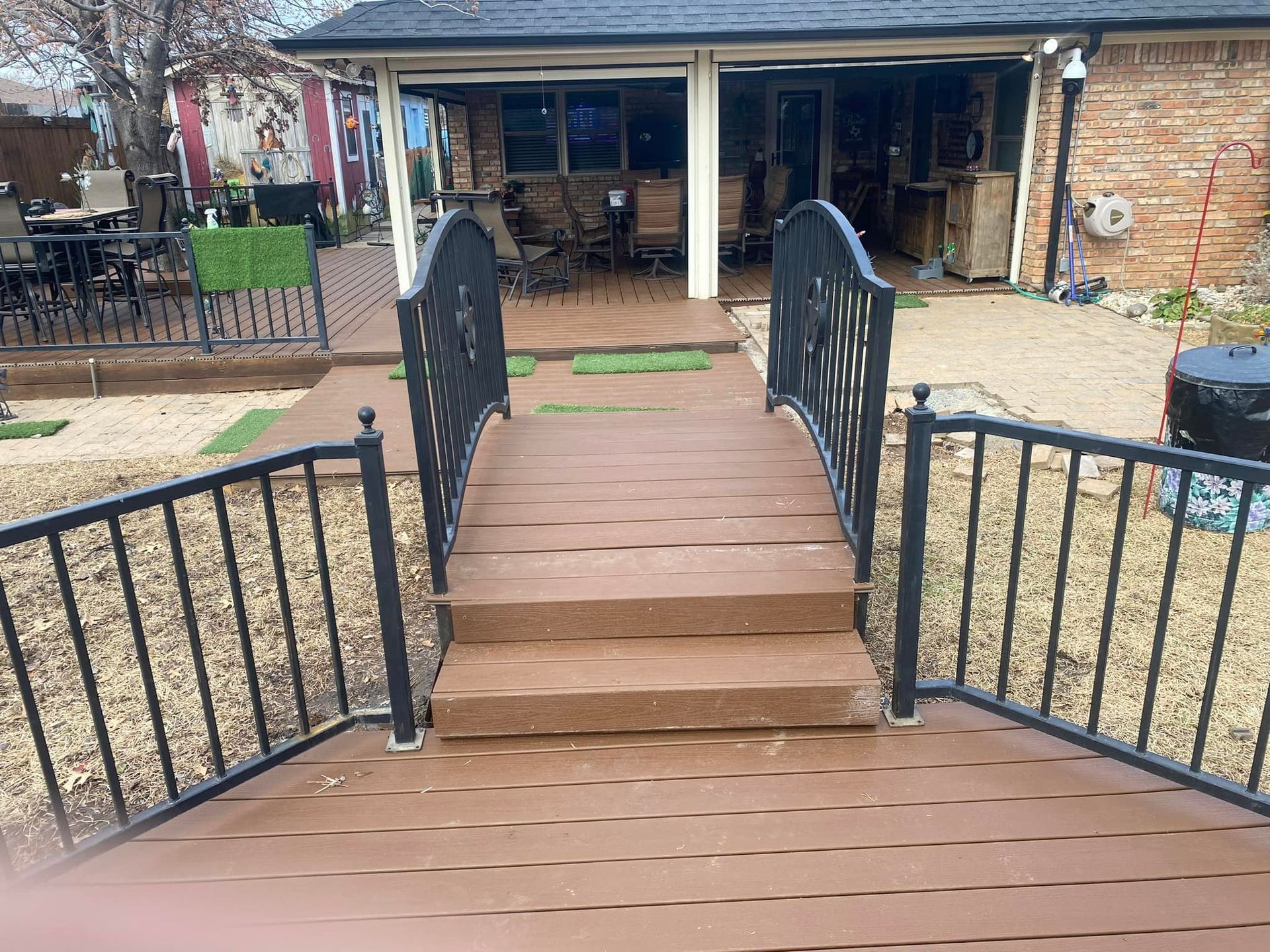 Wooden accessibility ramp with black railings leading to a house entrance