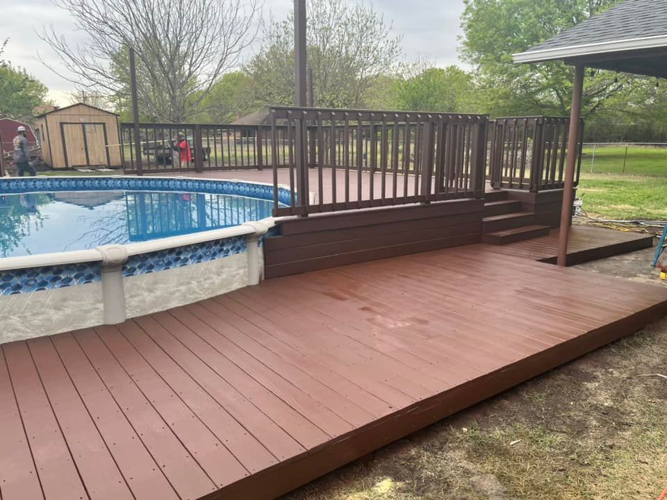 Wooden deck beside an above-ground pool in a backyard with trees and a shed