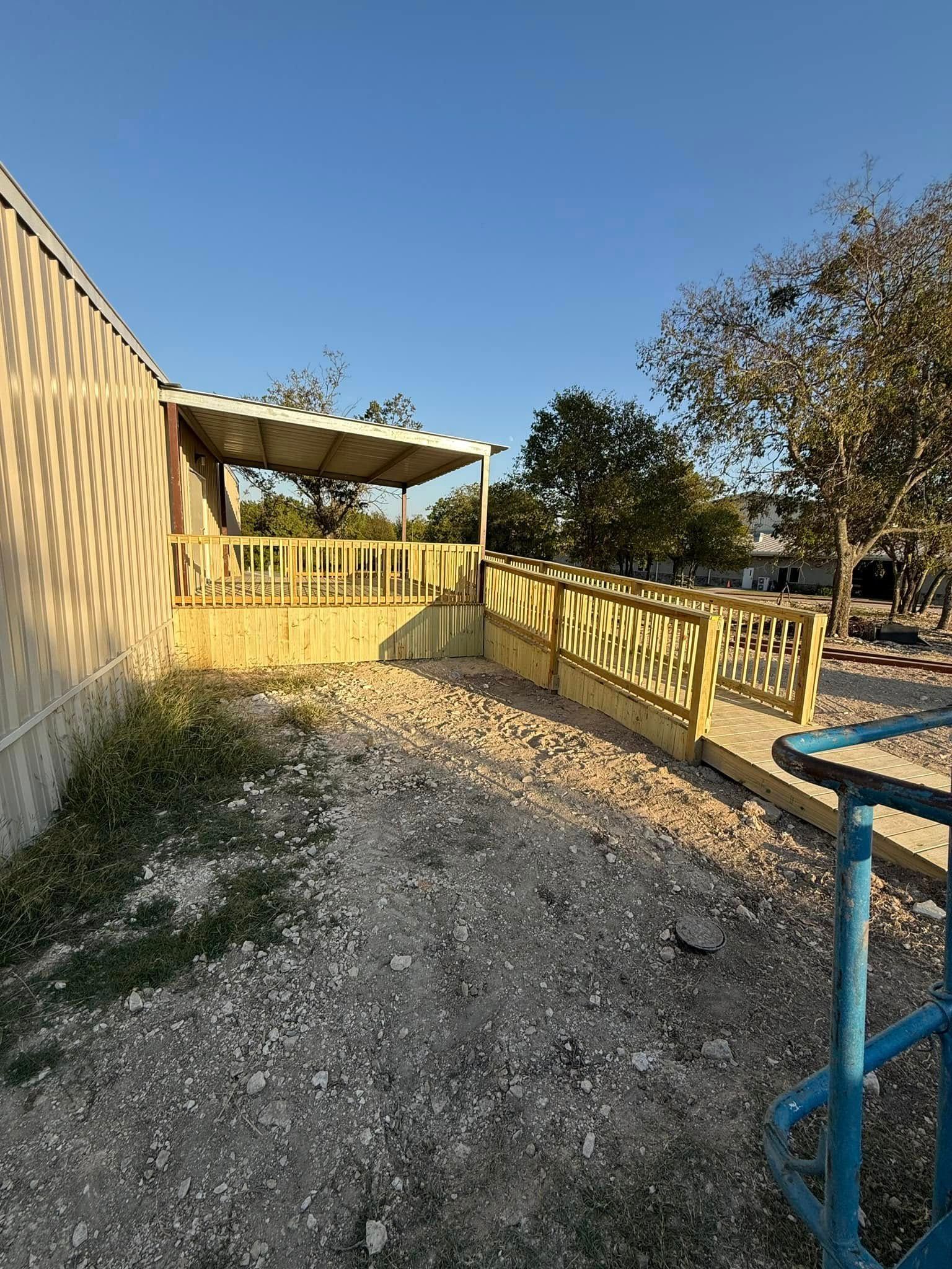 Yellow porch ramp and railing beside a house under a clear blue sky