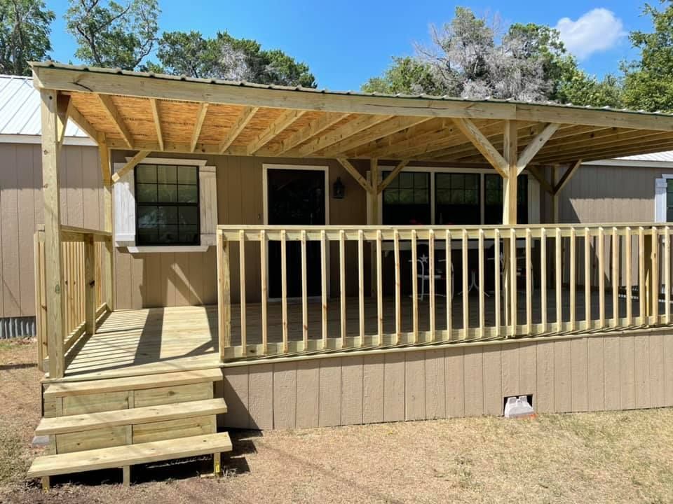 Wooden deck with steps, railing, and a covered porch on a beige manufactured home.