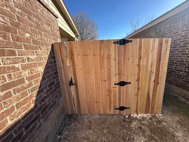 Wooden fence gate between two brick walls in a narrow outdoor passage