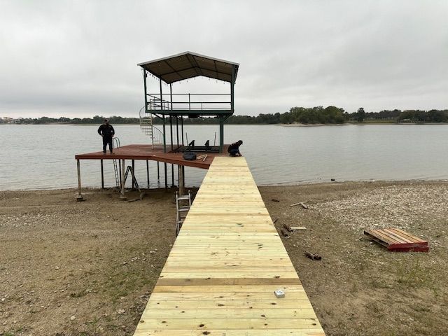 Wooden dock leading to a covered platform over a calm lake on a cloudy day