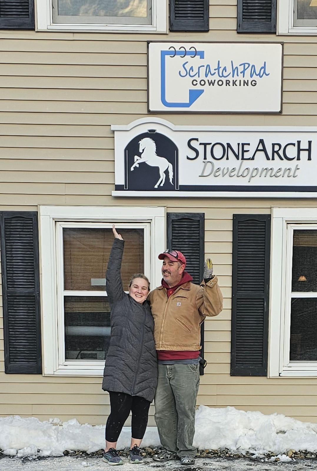 A couple celebrates outside a building marked with