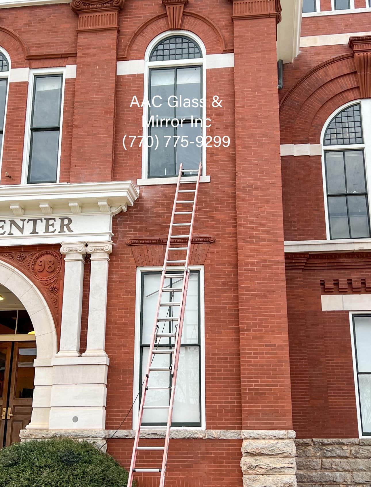 A red brick building with a ladder in front of it
