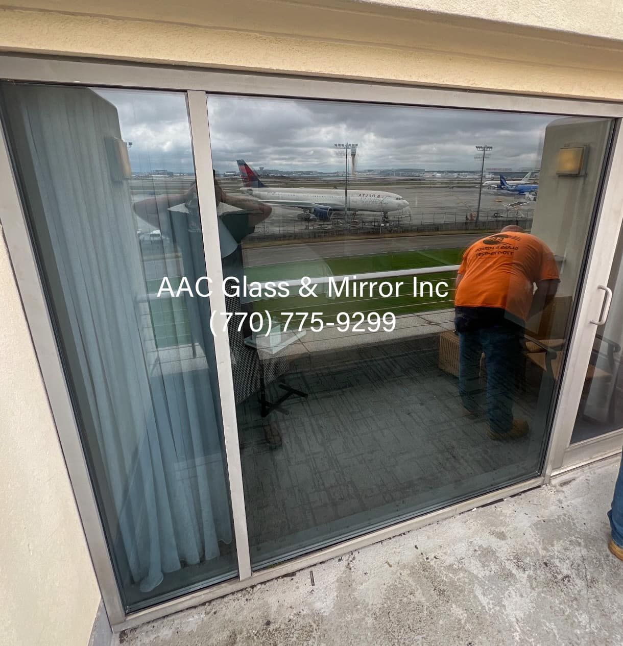 A man is working on a sliding glass door.