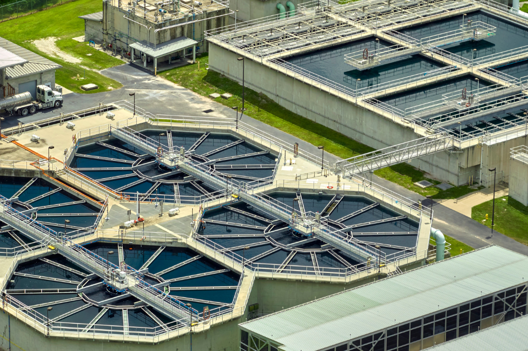Aerial view of a wastewater treatment plant with hexagonal sedimentation tanks and buildings.