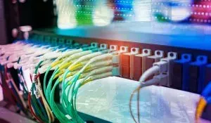 Server rack with colorful fiber optic cables connected to ports.