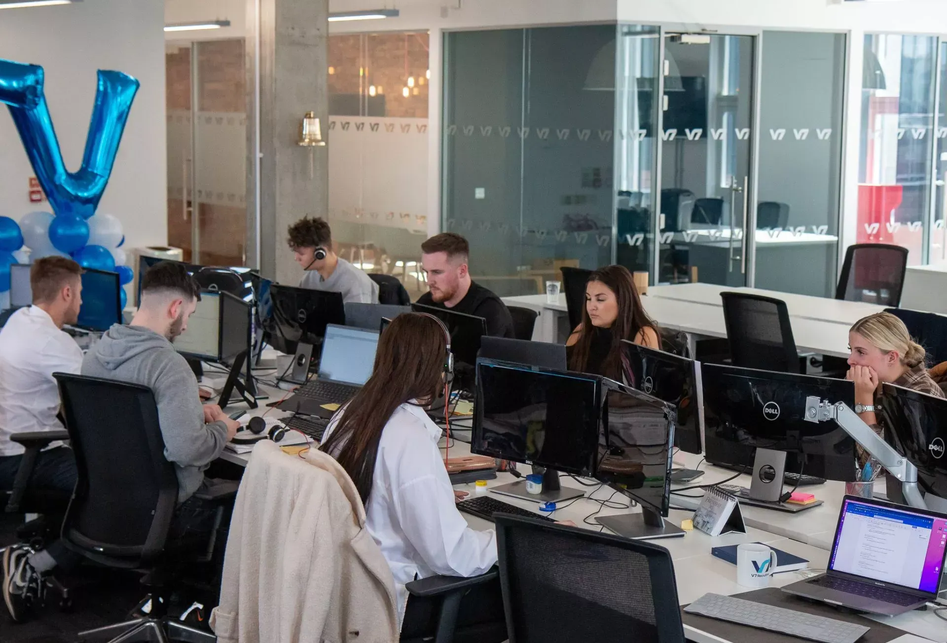 People working at computers in a modern office setting, large