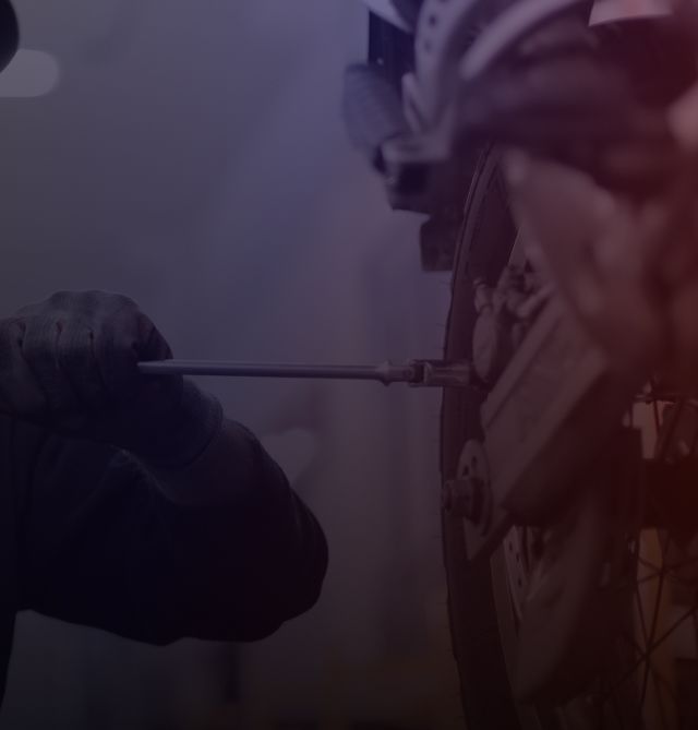 Gloved hand pointing at a firefighter’s helmet in a smoky, purple-lit scene | Tire Town Inc.