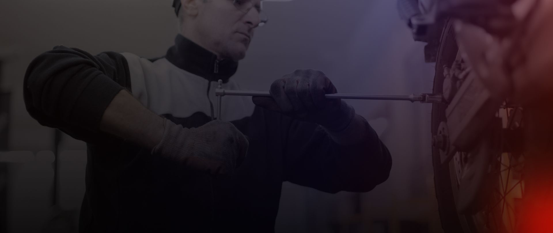 Person drawing a bow indoors, lit by dim purple and orange light | Tire Town Inc.