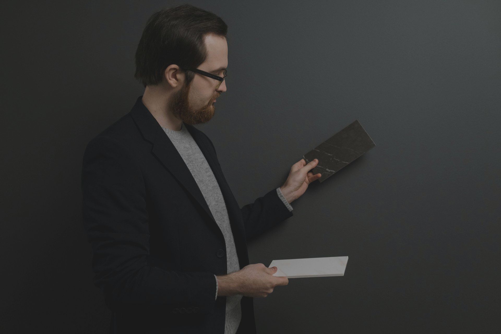 A man in a suit and glasses is holding a piece of paper.