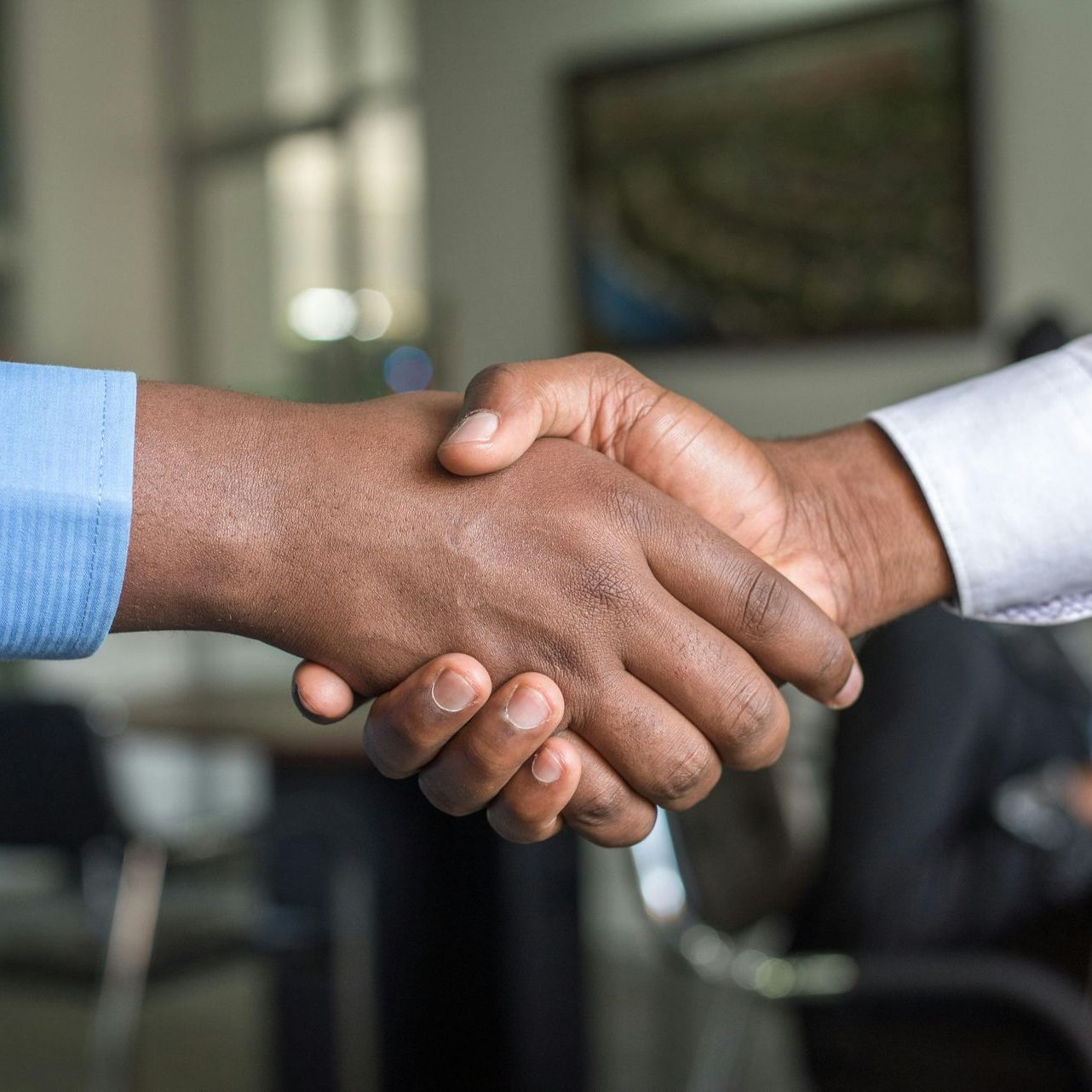 Two men are shaking hands in a room.