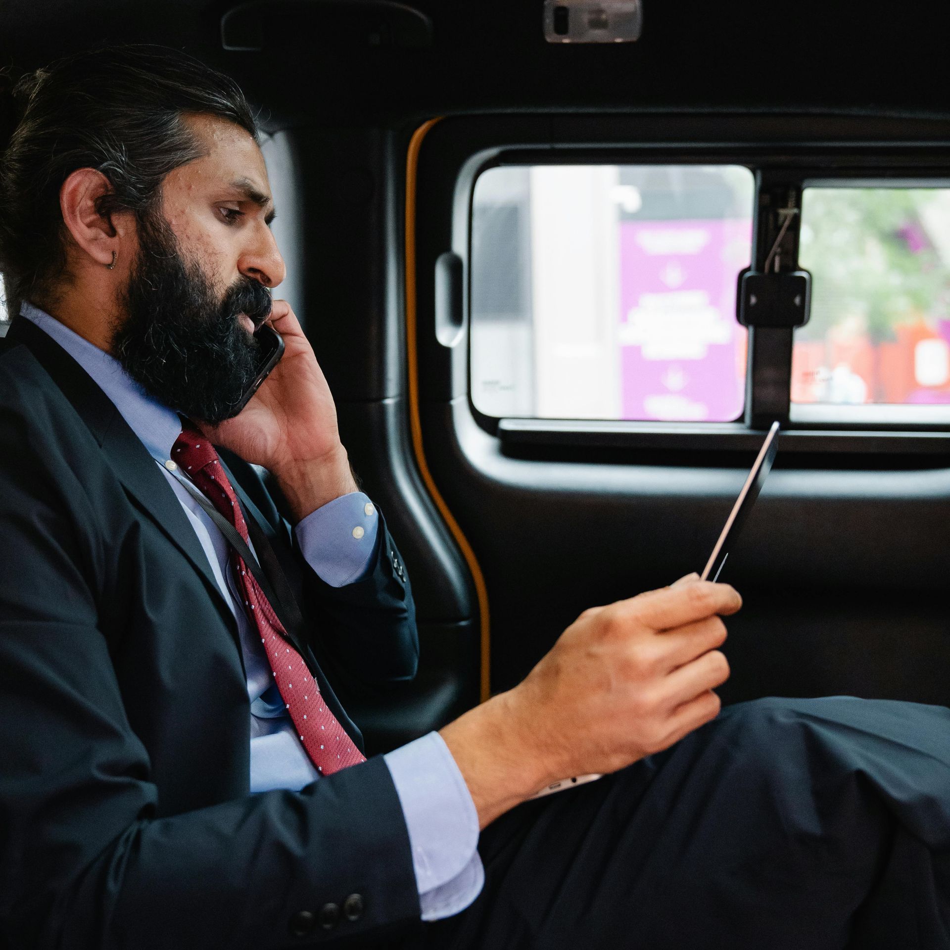 A man in a suit and tie is talking on a cell phone