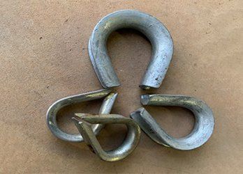 Three interlinked metal chain links on a tan surface