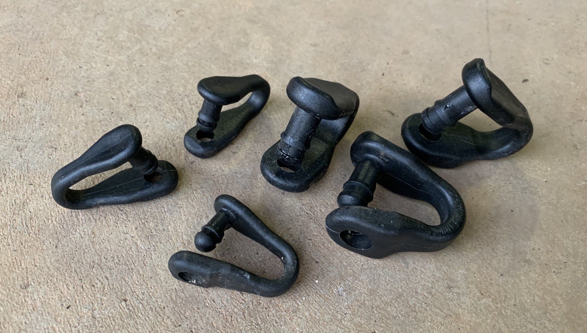 Several black push-up bars scattered on a beige carpet