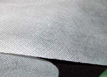 Close-up of a light gray textured fabric surface with a dark curved edge at the bottom.