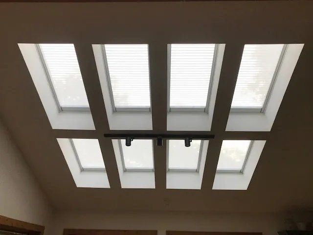 Ceiling with four rectangular skylights and a black light fixture underneath