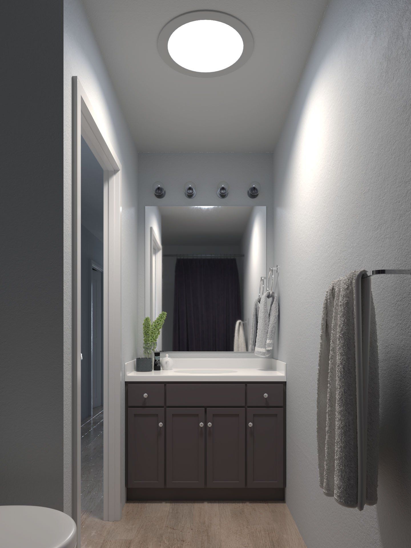 Narrow bathroom hallway with vanity, mirror, round ceiling light, and towel on the right wall.